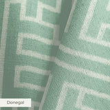 Greek key pattern in sage green and cream with geometric interlocking maze design