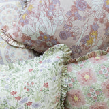Three decorative throw pillows with ruffled edges, featuring vintage floral and illustrated Disney Rapunzel patterns in soft pastel tones of pink, green, purple, and yellow.