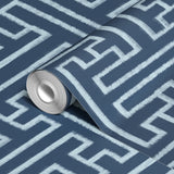 White geometric Greek key pattern on dark blue background